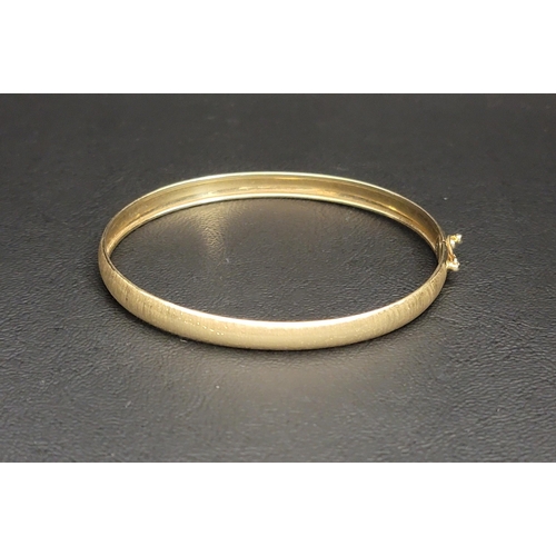 71 - FOURTEEN CARAT GOLD BANGLE 
with a brushed finish and safety clasp
approximately 4.2 grams