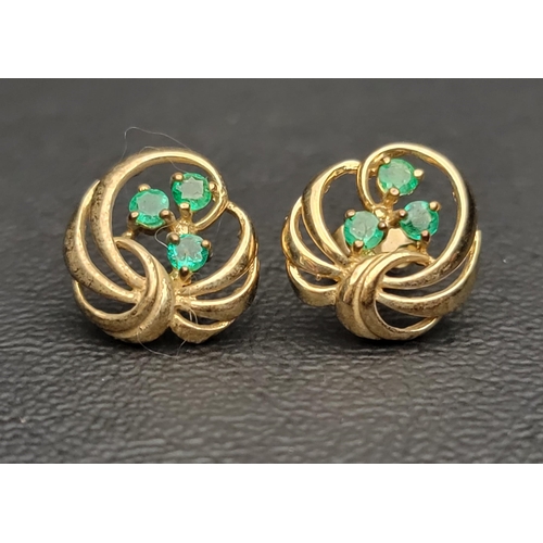 110 - PAIR OF EMERALD SET NINE CARAT GOLD EARRINGS
each earring with three emeralds in pierced and scrolli... 