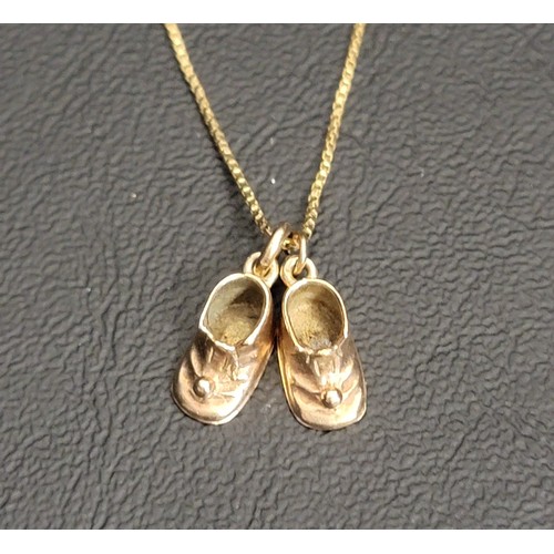 194 - TWO NINE CARAT GOLD BOOT PENDANTS 
on an eighteen carat gold chain, the pendants approximately 2.4 g... 