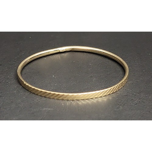 202 - NINE CARAT GOLD BANGLE 
with a diagonal hatched design, approximately 5.4 grams