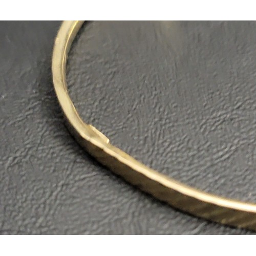 202 - NINE CARAT GOLD BANGLE 
with a diagonal hatched design, approximately 5.4 grams