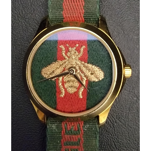 183 - GUCCI EMBROIDERED BEE WRISTWATCH 
the red and green fabric dial embroidered with a gold bee, on a re... 