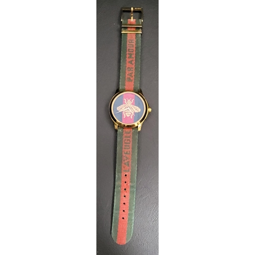 183 - GUCCI EMBROIDERED BEE WRISTWATCH 
the red and green fabric dial embroidered with a gold bee, on a re... 