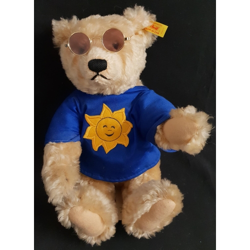 374 - STEIFF SUMMER GROWLER TEDDY BEAR
numbered 654473, wearing sunglasses a blue T shirt with the sun, wi... 