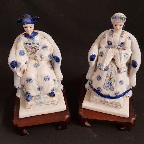 237 - PAIR OF PORCELAIN ASIAN FIGURINES
depicting a seated emperor and empress, on hardwood stands, 20.5cm... 