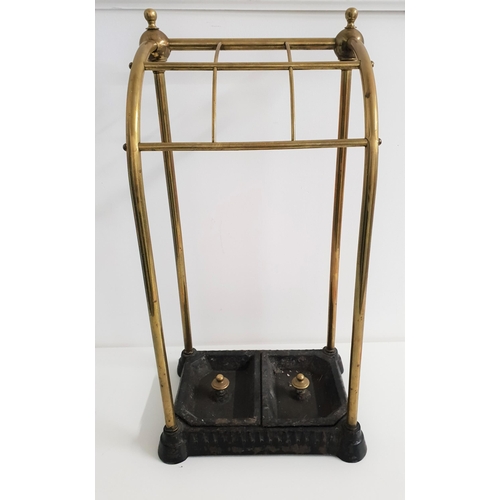 499 - BRASS AND CAST IRON STICK STAND
with six open sections above two removeable drip pans, 63.5cm high