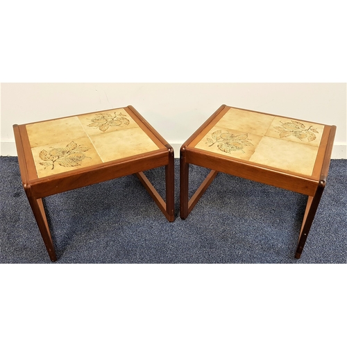 PAIR OF STAINED TEAK OCCASIONAL TABLES
with inset tiled tops, standing on continuous loop supports, 36cm high