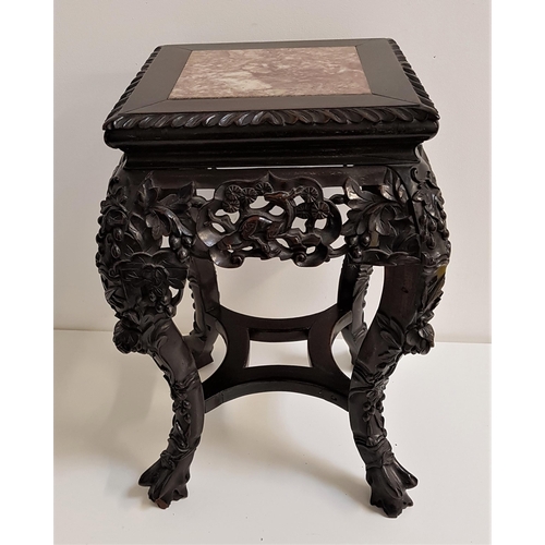 557 - CHINESE HARDWOOD STAND
with a square top inset with pink marble, above a pierced carved frieze, stan... 