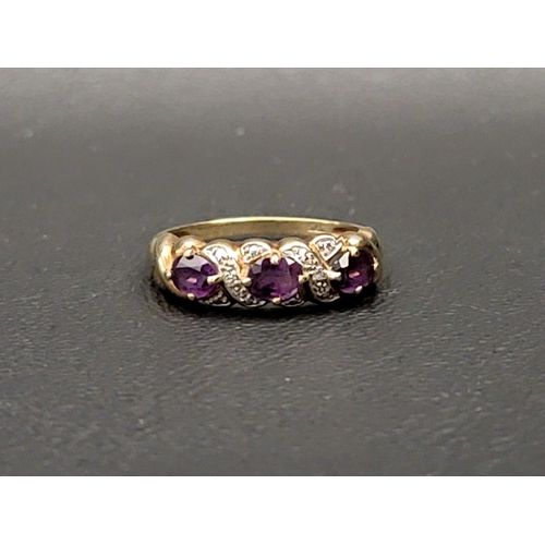 102 - AMETHYST AND DIAMOND DRESS RING
the three oval cut amethysts separated by small illusion set diamond... 