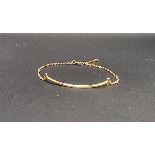 106 - TIFFANY & CO. EIGHTEEN CARAT GOLD SMILE BRACELET
the chain bracelet with a central curved double end... 