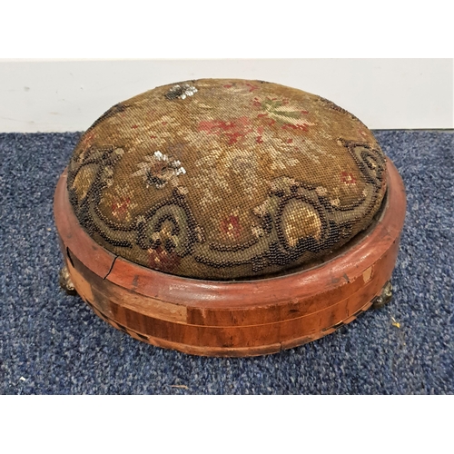 572 - VICTORIAN WALNUT FOOTSTOOL
with a circular needlework padded top on a circular frame with three stou... 