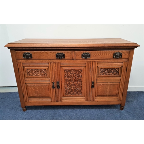 503 - EDWARDIAN LIGHT OAK SIDEBOARD
with a moulded top above two panelled frieze drawers with three carved... 