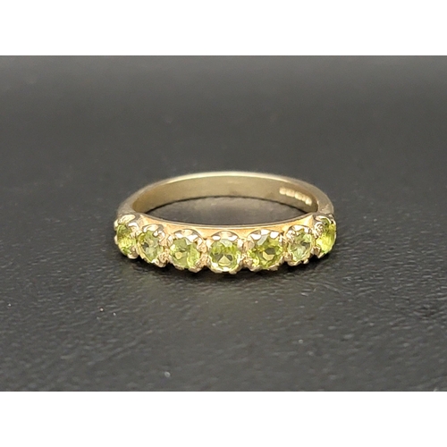 51 - PERIDOT HALF ETERNITY RING 
the seven round cut peridots totalling approximately 0.5cts on a nine ca... 