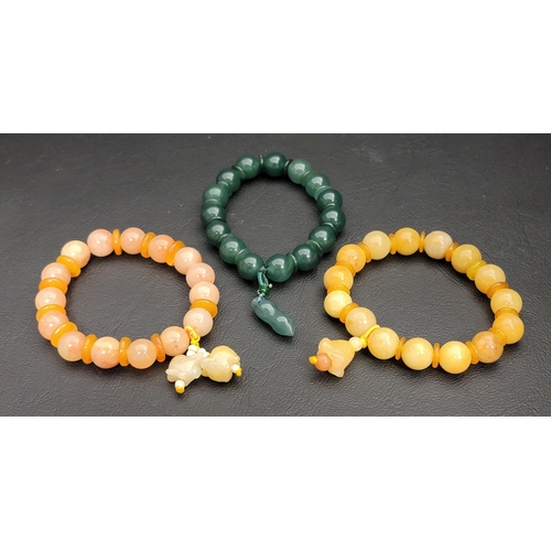 159 - THREE STONE BEAD BRACELETS
of varying colours including a jade coloured example, all with disc space... 