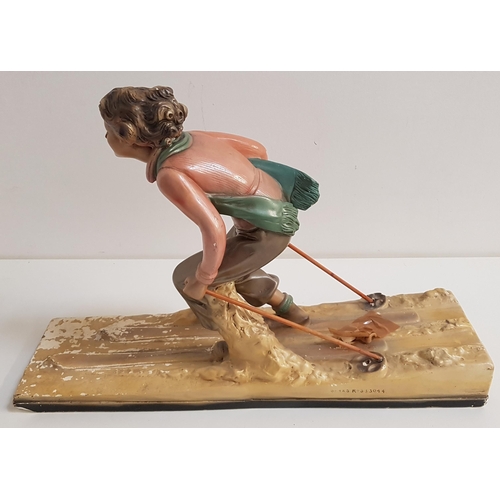 242 - ART DECO POLYCHROME PLASTER FIGURINE
of a female skier on a naturalistic rectangular base stamped OP... 