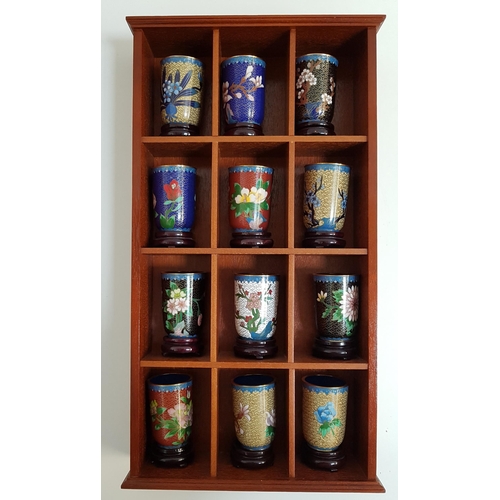 253 - SET OF TWELVE CHINESE CLOISONNE BEAKERS
each with a circular hardwood stand, in a wall mounted case