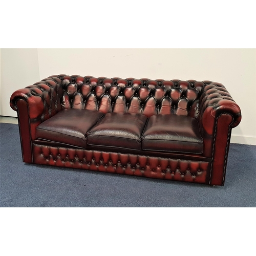 417 - CHESTERFIELD SOFA
with a deep button back and arms with decorative metal stud detail, covered in ox ... 