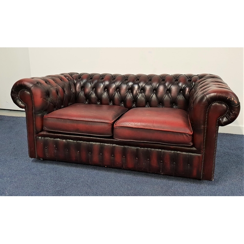 428 - CHESTERFIELD SOFA
with a deep button back and arms with decorative metal stud detail, covered in ox ... 