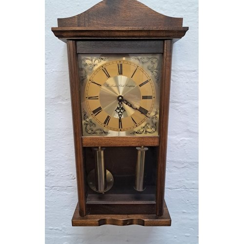 300 - THE LONDON CLOCK COMPANY WALL CLOCK
in an oak case with a brass dial with Roman numerals and a quart... 