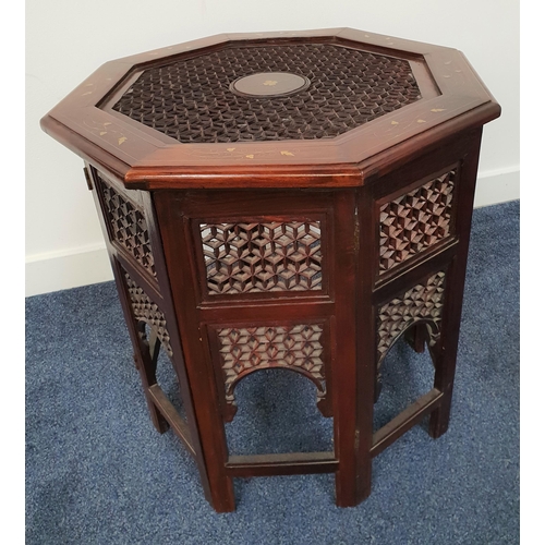 415 - TEAK AND BRASS INLAID OCCASIONAL TABLE
with a carved and pierced octagonal top on a carved and foldi... 