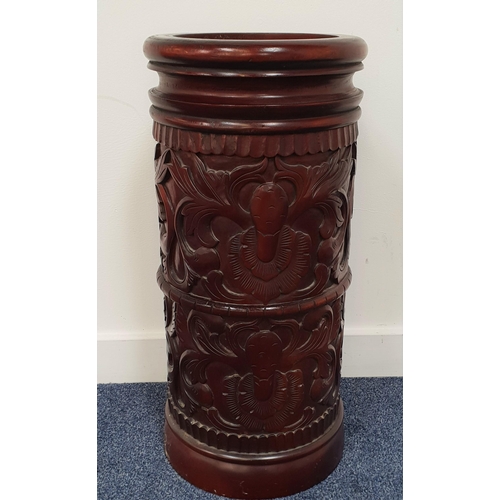 420 - CARVED TEAK STICK STAND
of cylindrical form with floral decoration, 60cm high