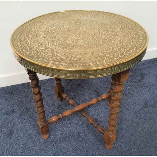 439 - MIDDLE EASTERN OCCASIONAL TABLE
with an embossed circular brass top on a barley twist base, 56.5cm h... 