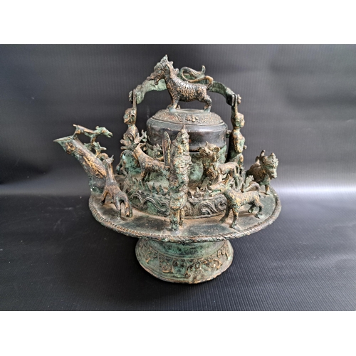 213 - 19th CENTURY MALAY BRONZE KETTLE
with a fold over lizard decorated handle with grotesque figures to ... 