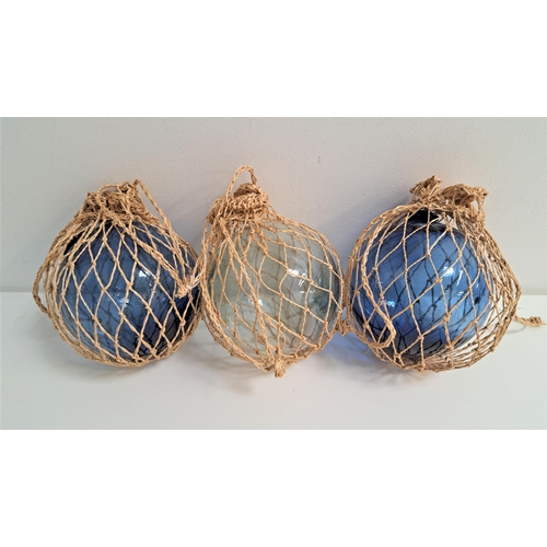 216 - THREE GLASS FISHING NET FLOATS
two blue glass and one clear glass, in net bags (3)