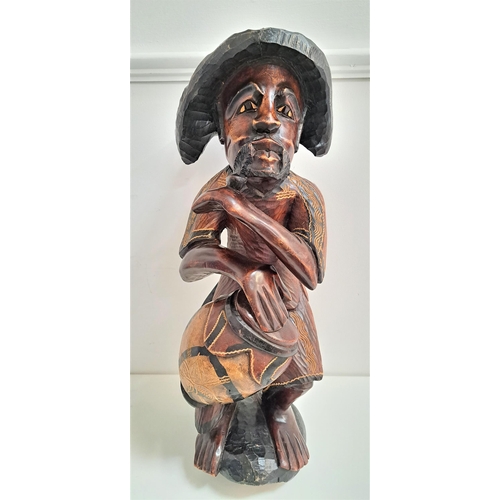 221 - CARVED TEAK CARIBBEAN FIGURE
depicting a man wearing a hat seated with a drum, 70cm high