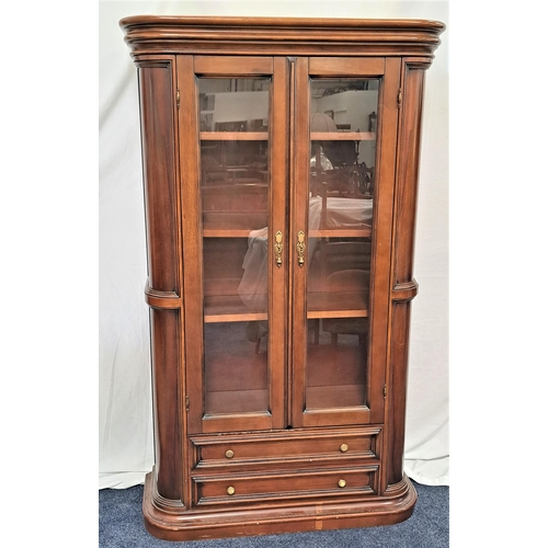 394 - TEAK CABINET
with a moulded pediment above a pair of glass doors opening to reveal adjustable shelve... 