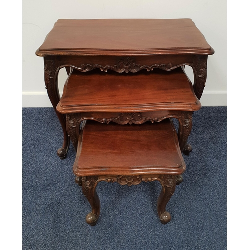 407 - NEST OF TEAK TABLES
with shaped tops above a carved frieze, standing on cabriole supports, 56cm high