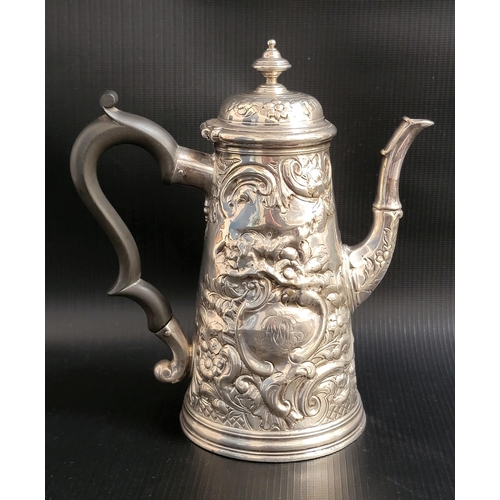 128 - GEORGE II SILVER COFFEE POT 
the conical pot with profuse embossed floral and scroll decoration, the...