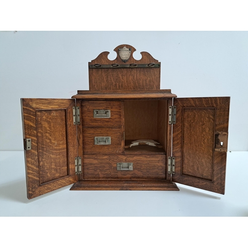 189 - EDWARDIAN OAK SMOKERS CABINET
the shaped raised back with a presentation plaque above a stand for fo... 