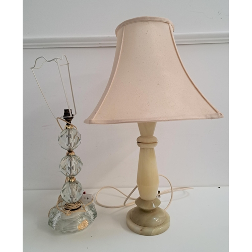 360 - TWO TABLE LAMPS
one carved geometric onyx lamp with a cream shade, approximately 64cm high; and a ca... 