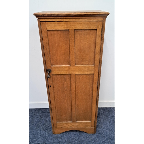 351 - 1930s NARROW OAK CABINET
with a moulded top above a panelled door opening to reveal a shelved interi... 