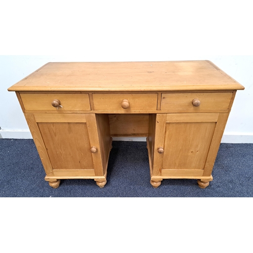 366 - WAXED PINE KNEEHOLE DESK
with a moulded top above three frieze drawers and two panelled cupboard doo... 