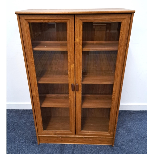 386 - TEAK EFFECT BOOKCASE
with a rectangular top above two glass panel doors opening to reveal a shelved ... 