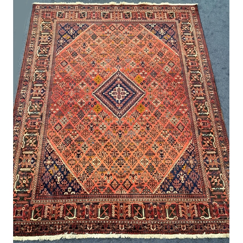 410 - PERSIAN JOSHAGAN RUG
with a red ground and a central blue ground diamond encased by floral motifs an... 