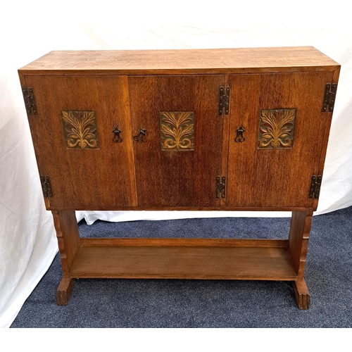 414 - ARTS AND CRAFTS OAK SIDE CABINET
with a plain rectangular top above three cupboard doors with carved... 