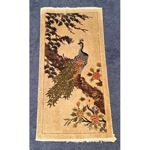 445 - CHINESE RUG
the beige ground decorated with a peacock in a tree, 124cm x 62cm