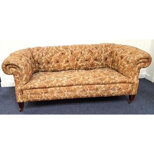 408 - EDWARDIAN CHESTERFIELD SOFA
with a button back and scroll arms, covered in a floral brocade, standin... 