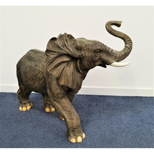 216 - LARGE RESIN ELEPHANT
with his trunk raised and ears extended forward, 82cm high