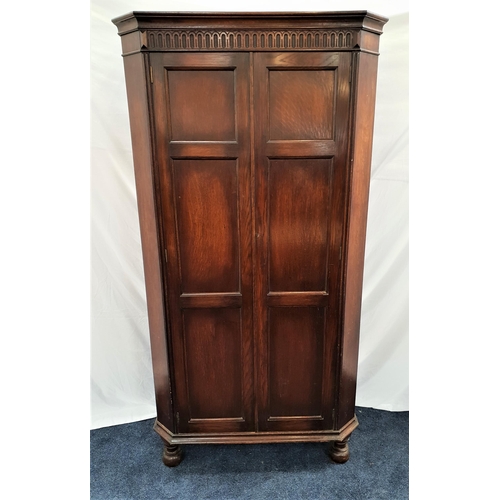 395 - OAK WARDROBE
with a pair of panelled doors flanked by canted corners, the interior with a mirror, sh... 