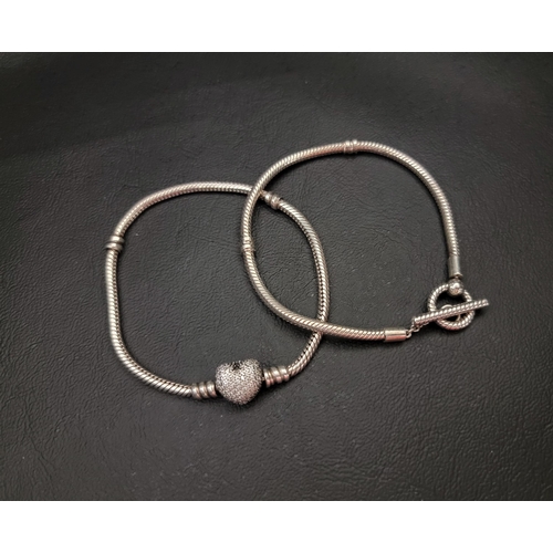 75 - TWO PANDORA BRACELETS
comprising a Moments T-Bar Snake Chain bracelet and a Moments Sparkling Heart ... 