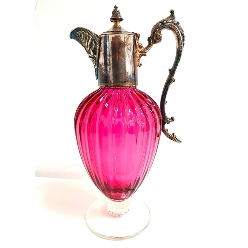 170 - LATE VICTORIAN CRANBERRY GLASS CLARET JUG
with a lobed body and silver plated mounts, raised on a ci... 