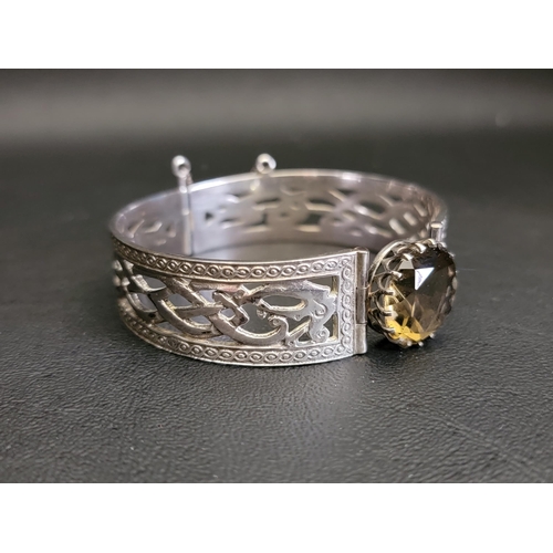 46 - SCOTTISH SILVER BANGLE
with central round cut citrine flanked by pierced Celtic motif decoration, Ed... 