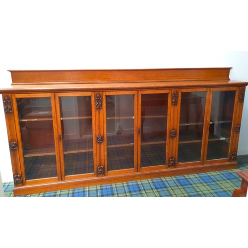 385 - LARGE EDWARDIAN OAK BOOKCASE
with a shaped raised back above a moulded top with six glass cupboard d... 