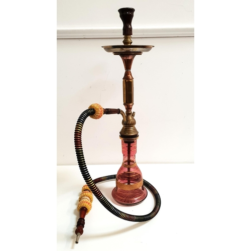 230 - MIDDLE EASTERN HOOKAH/SHISHA PIPE
with a cranberry glass reservoir and a brass and copper stack, wit... 