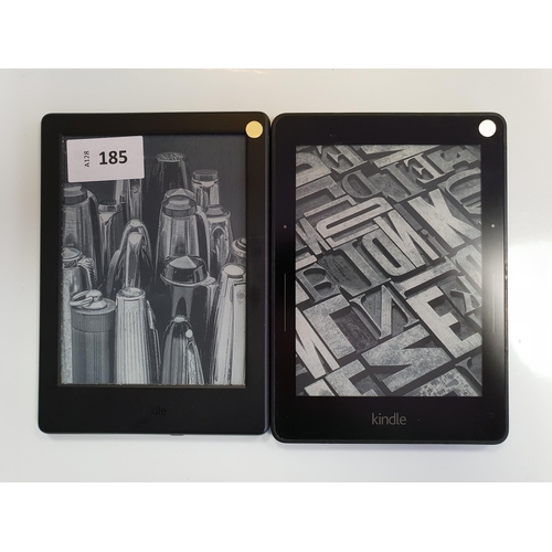 185 - TWO AMAZON KINDLE E-READERS
comprising a Votage, serial number B013 0907 4395 00RJ; and a Basic 2, s... 