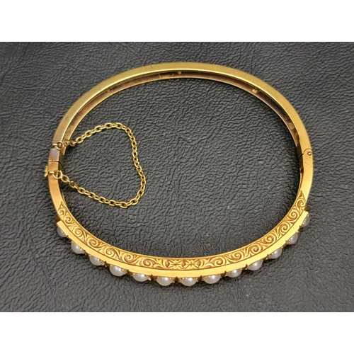 64 - PEARL SET UNMARKED HIGH CARAT GOLD BANGLE
late 19th/early 20th century, the bangle with engraved scr... 